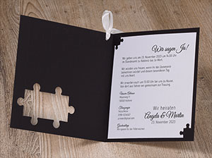 Aufgeklappte Hochzeitseinladung mit Texteinleger.