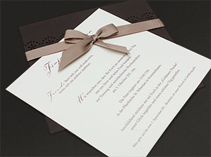 Der Texteinleger der Hochzeitseinladung, schräg unter die Satin-Schleife geschoben.
